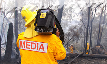 A camera operator filming a hazard reduction burn