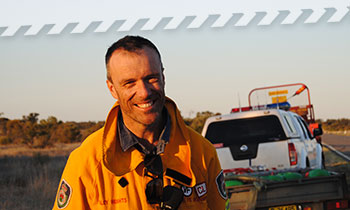 A firefighter standing on the side of the road in a rural area